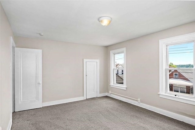 spare room featuring carpet and baseboards