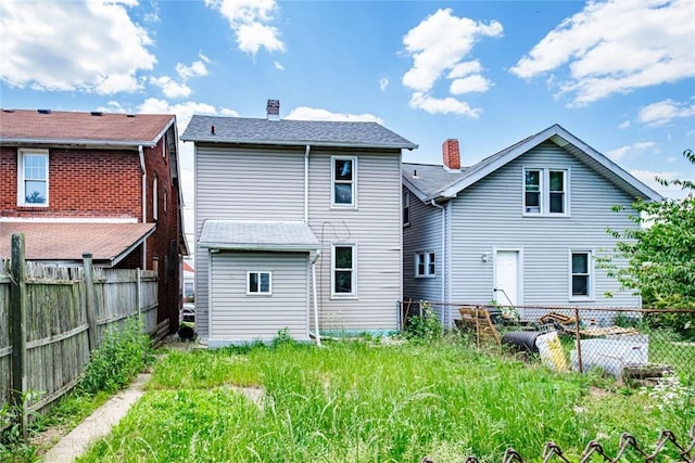 rear view of house with a fenced backyard