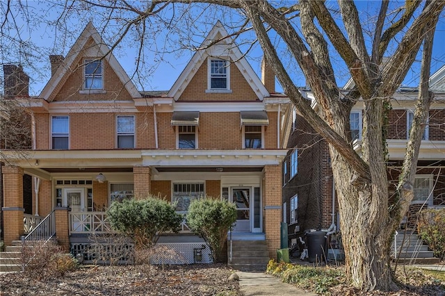 view of front of home featuring brick siding and covered porch