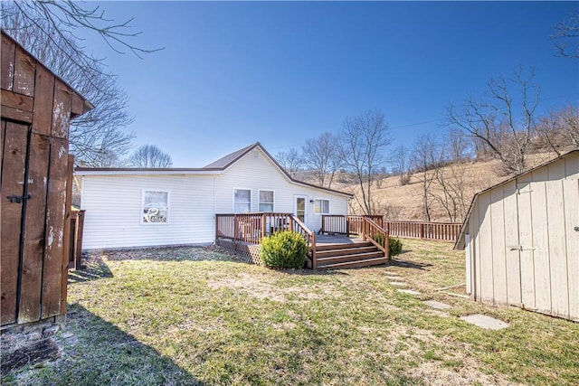 rear view of house featuring a yard, a deck, a storage shed, and an outdoor structure