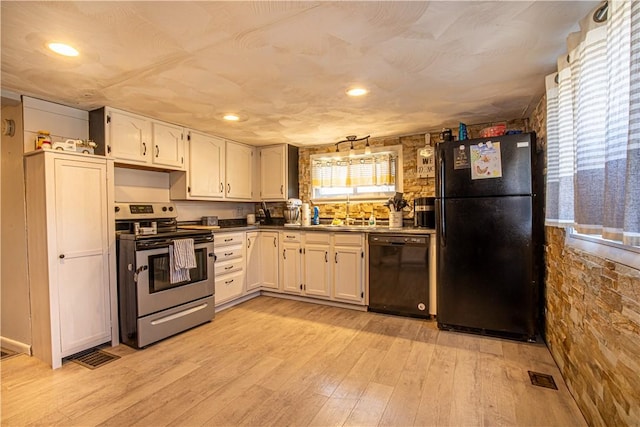 kitchen featuring visible vents, a sink, black appliances, white cabinets, and light wood-type flooring