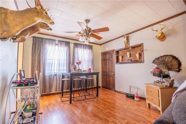 home office with crown molding, wood finished floors, baseboards, and ceiling fan