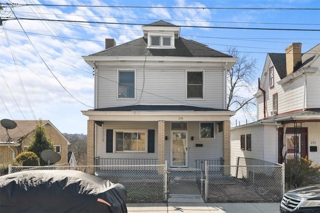 american foursquare style home featuring a gate, covered porch, and a fenced front yard