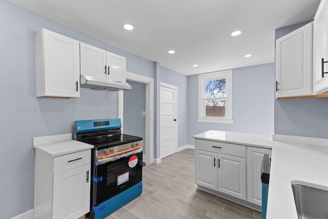 kitchen with under cabinet range hood, white cabinets, stainless steel electric range oven, and light countertops