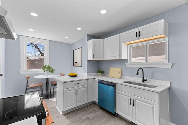 kitchen featuring electric range, a sink, a peninsula, white cabinets, and dishwasher