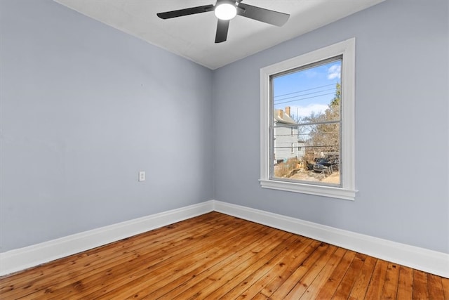 spare room featuring a ceiling fan, baseboards, and wood-type flooring