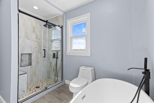 full bath featuring a freestanding tub, a marble finish shower, baseboards, and toilet