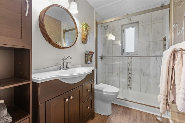 full bath with a shower stall, toilet, vanity, and wood finished floors