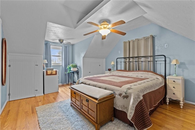 bedroom with vaulted ceiling, light wood-style floors, and ceiling fan