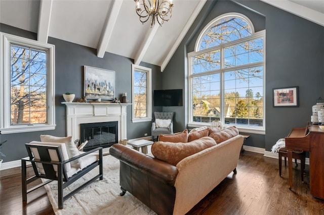 living area with beamed ceiling, high vaulted ceiling, a glass covered fireplace, wood finished floors, and baseboards