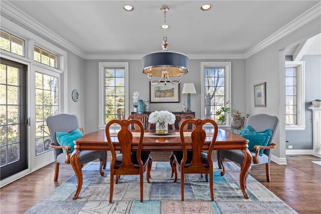 dining room with recessed lighting, ornamental molding, baseboards, and wood finished floors