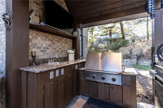 view of patio featuring an outdoor kitchen, area for grilling, and a sink