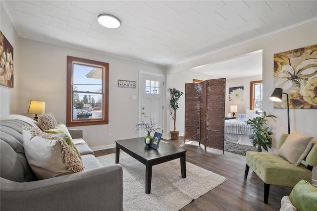 living room with crown molding, baseboards, and dark wood-style flooring