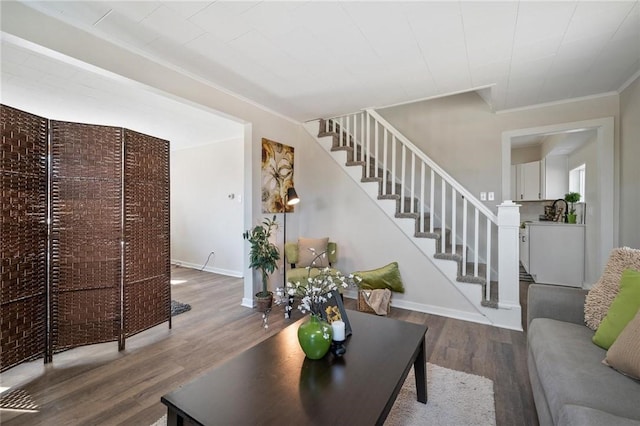 living room with baseboards, brick wall, wood finished floors, and stairs