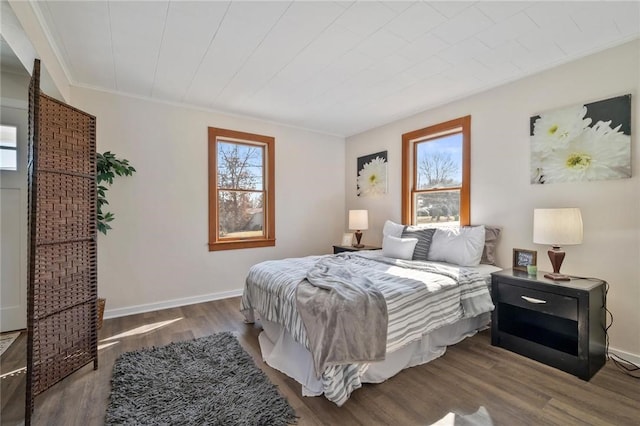 bedroom with wood finished floors, baseboards, and ornamental molding