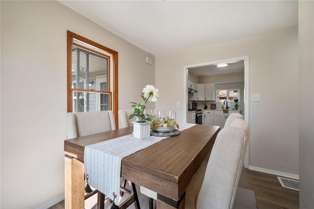 dining area with visible vents, baseboards, and wood finished floors