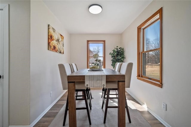 dining space featuring baseboards and wood finished floors