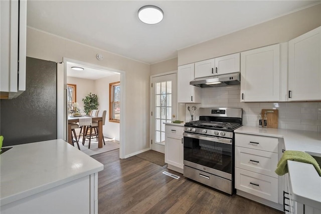 kitchen featuring under cabinet range hood, stainless steel appliances, light countertops, and tasteful backsplash