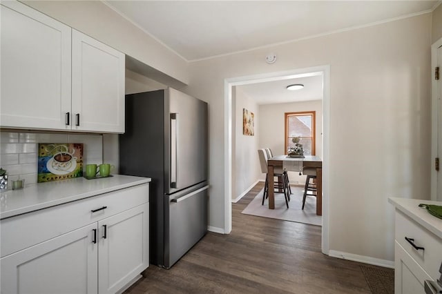 kitchen with backsplash, dark wood-style floors, light countertops, and freestanding refrigerator