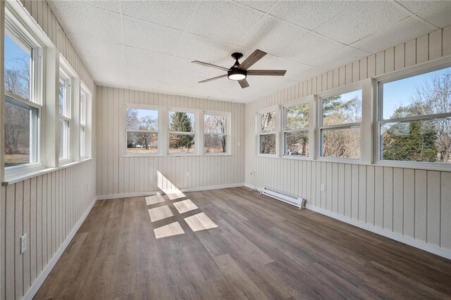 unfurnished sunroom with ceiling fan, plenty of natural light, and a baseboard radiator