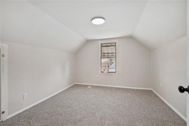 additional living space featuring carpet flooring, baseboards, and lofted ceiling