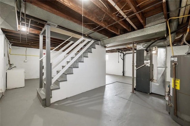 unfinished basement with stairway, refrigerator, heating unit, and water heater