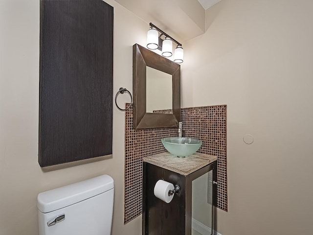 half bath featuring vanity, tile walls, and toilet