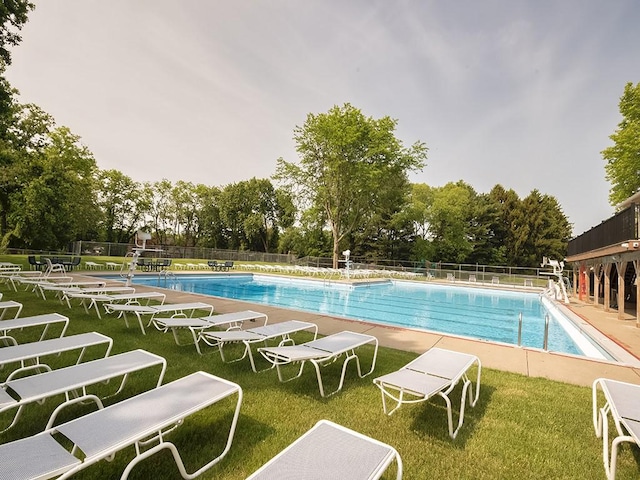 pool featuring a patio, fence, and a lawn