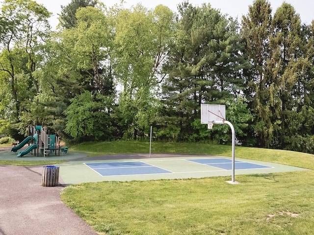 view of basketball court with community basketball court, a lawn, and playground community