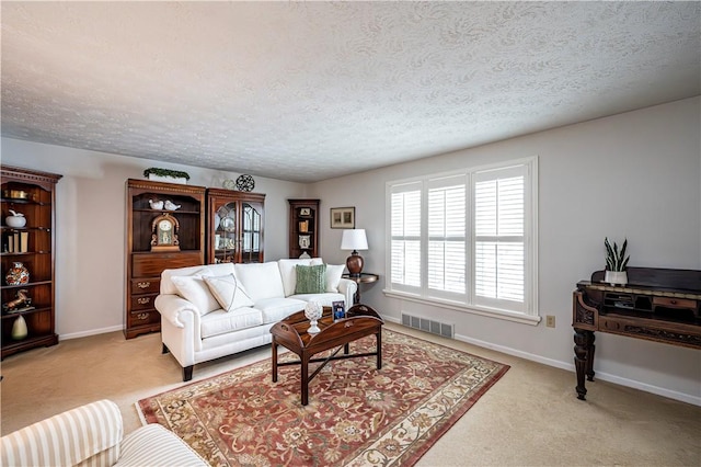 living area featuring baseboards, visible vents, and light carpet