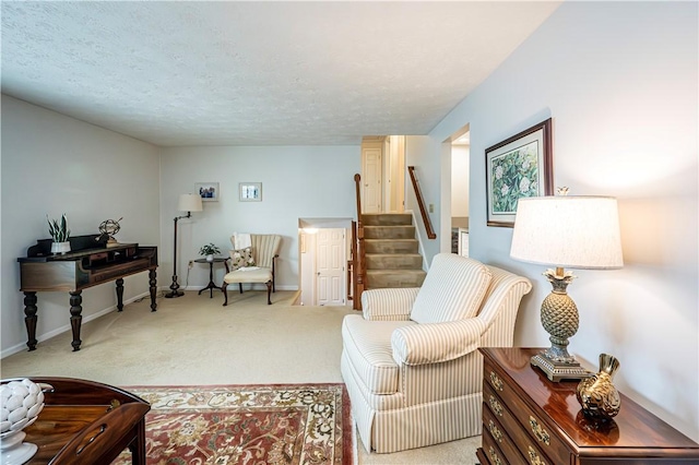 sitting room featuring stairway, baseboards, carpet floors, and a textured ceiling