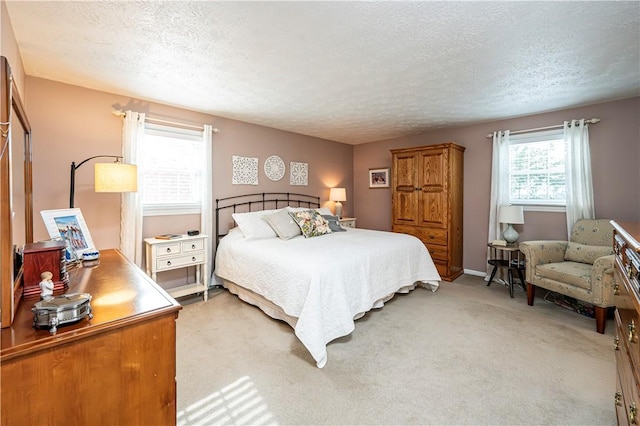 bedroom with light carpet and a textured ceiling