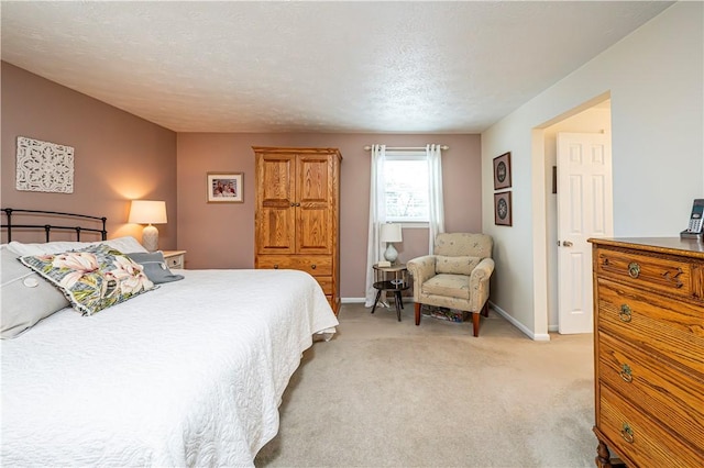 bedroom featuring light carpet, a textured ceiling, and baseboards