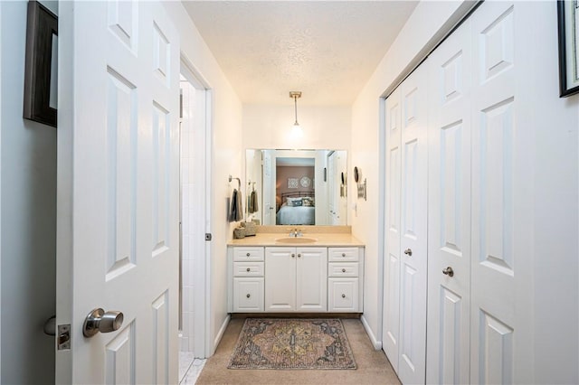 full bath featuring vanity, ensuite bath, baseboards, and a textured ceiling