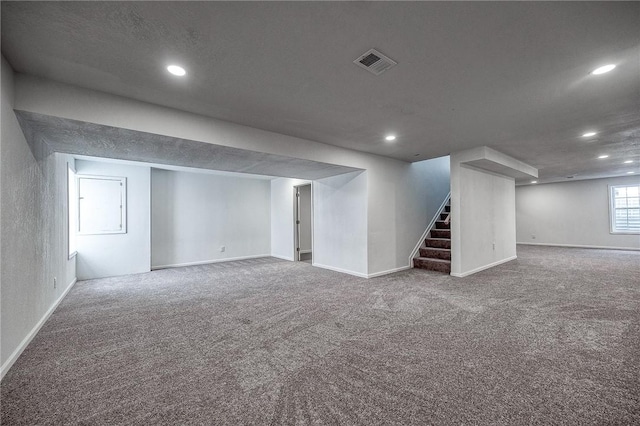 below grade area with stairs, recessed lighting, visible vents, and carpet floors