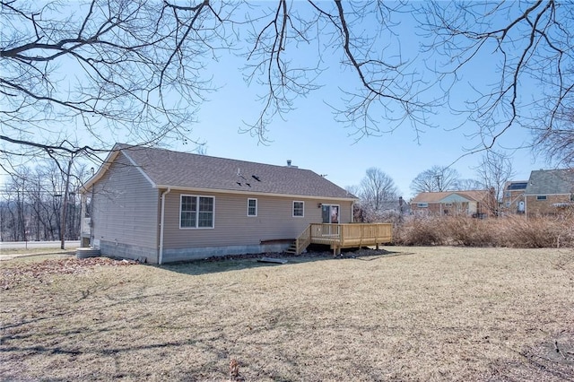 rear view of house with a deck, a yard, and a shingled roof