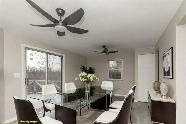 dining room with a ceiling fan, baseboards, and wood finished floors