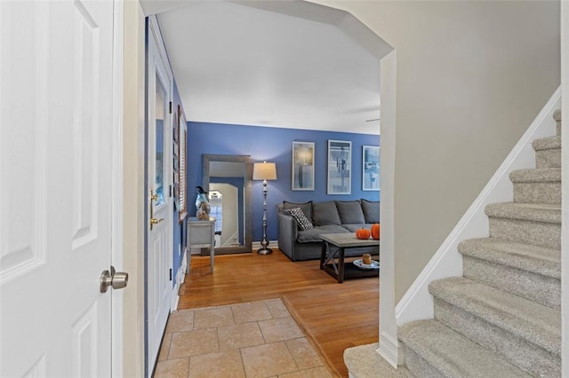 entryway featuring stairway, baseboards, and light wood-style floors