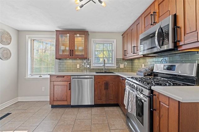 kitchen featuring brown cabinetry, appliances with stainless steel finishes, and a sink