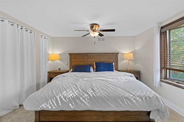 bedroom featuring visible vents, multiple windows, carpet, and ceiling fan