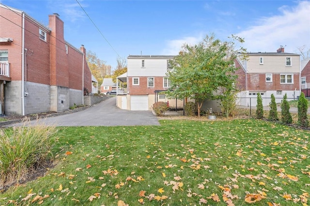 view of yard featuring a garage, driveway, and fence