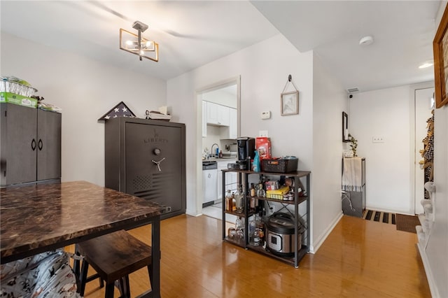 dining room featuring a chandelier, baseboards, and light wood-style floors