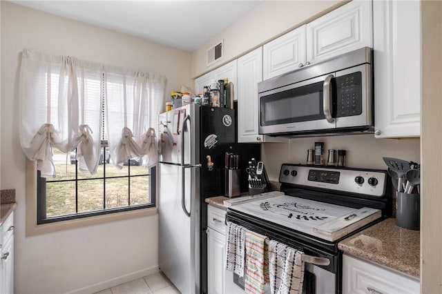 kitchen featuring visible vents, light stone counters, white cabinetry, stainless steel appliances, and light tile patterned flooring