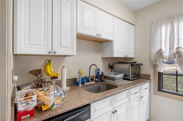 kitchen featuring white cabinetry, light stone counters, a toaster, and a sink