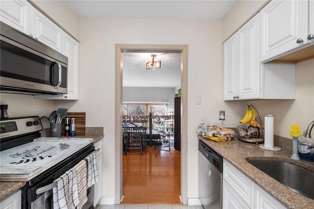 kitchen featuring a sink, stone counters, appliances with stainless steel finishes, and white cabinets