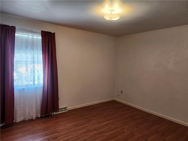 empty room featuring dark wood finished floors, visible vents, a healthy amount of sunlight, and baseboards