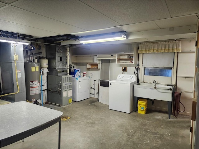 basement featuring a sink, heating unit, independent washer and dryer, and water heater