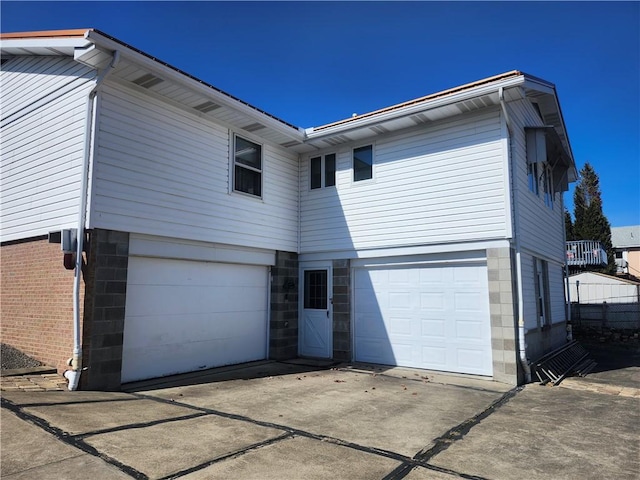 back of house featuring concrete driveway and a garage