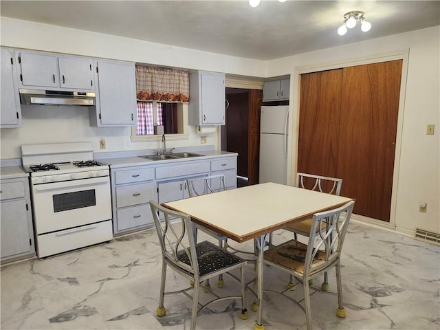 kitchen featuring visible vents, under cabinet range hood, marble finish floor, white appliances, and a sink