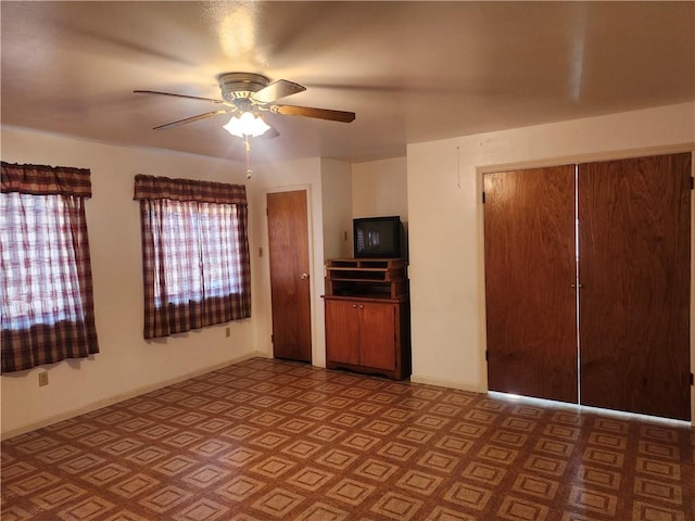 interior space with ceiling fan and baseboards